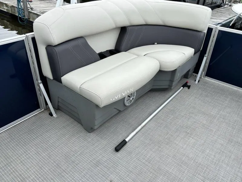 Slide: The Image of 2022 Sylvan Mirage 8522 Resorter boat interior with cushioned seating and a boat hook. - 4
