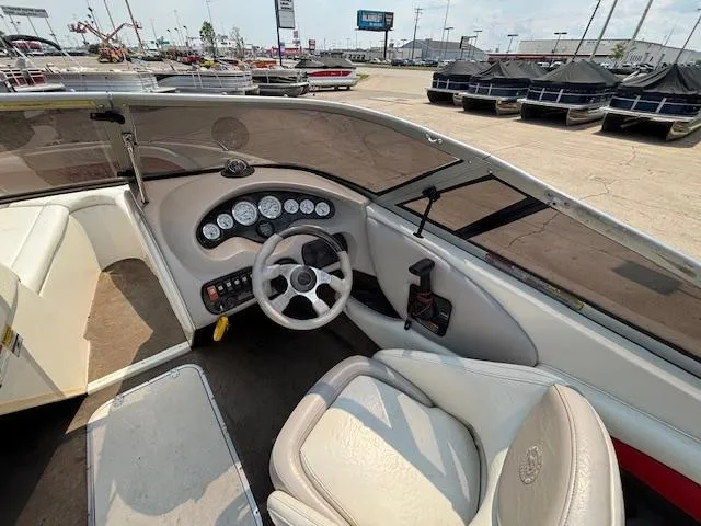 Slide: The Image of Interior of a 2006 Stingray 220 LX boat, featuring steering wheel and dashboard controls. - 13