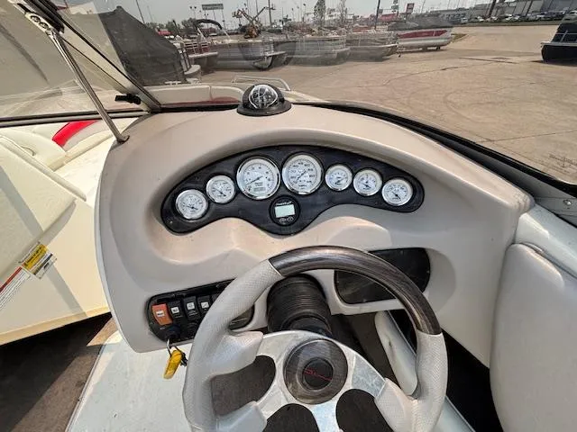 Slide: The Image of 2006 Stingray 220 LX boat dashboard with gauges and steering wheel. - 14