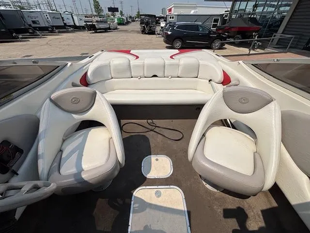 Slide: The Image of 2006 Stingray 220 LX boat interior with white and gray seating, parked in a lot. - 22