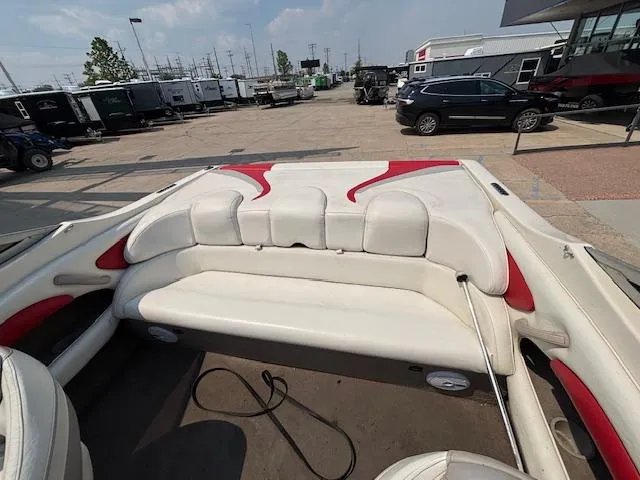 Slide: The Image of 2006 Stingray 220 LX boat interior with white and red seating, parked outdoors. - 23