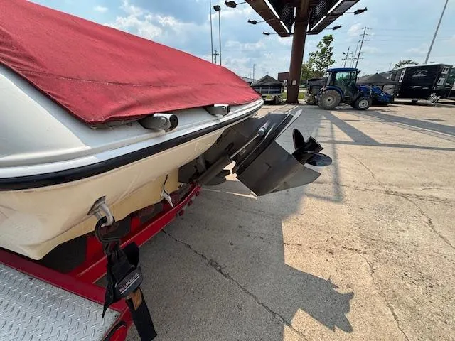Slide: The Image of 2006 Stingray 220 LX boat with red cover and visible propeller, parked on concrete. - 3