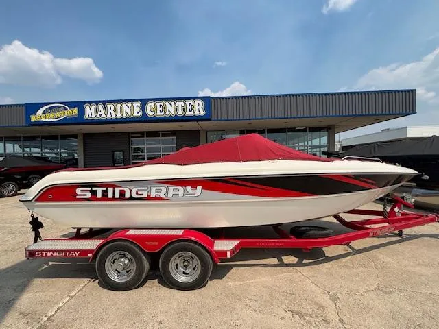 Slide: The Image of 2006 Stingray 220 LX boat with red cover on trailer, parked outside Marine Center. - 5