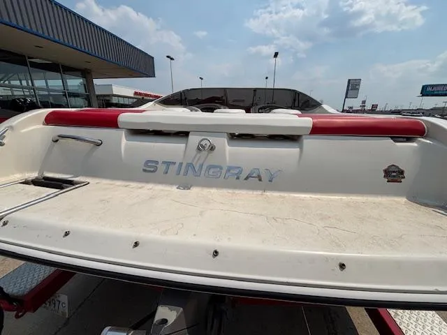 Slide: The Image of 2006 Stingray 220 LX boat rear view, parked outdoors under a partly cloudy sky. - 7