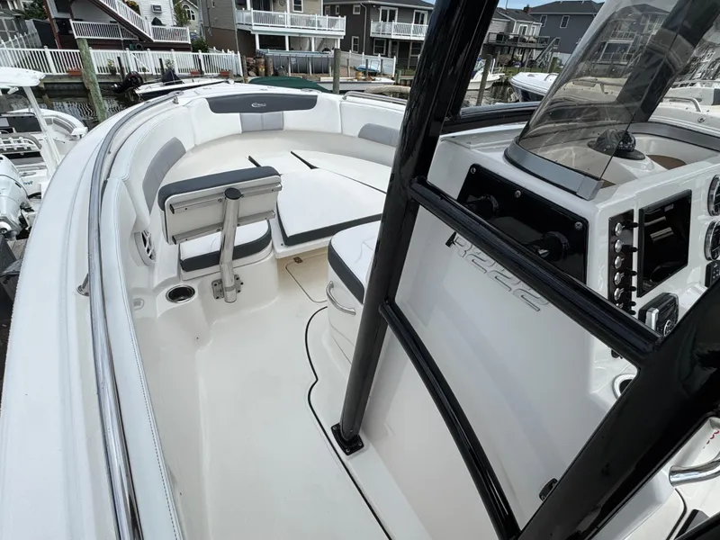 Slide: The Image of 2021 Robalo R222 Explorer boat interior with seating and control panel, docked near waterfront homes. - 10
