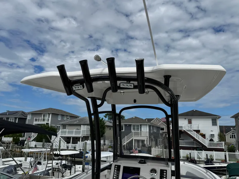 Slide: The Image of 2021 Robalo R222 Explorer boat with T-top, docked in a marina under a cloudy sky. - 3