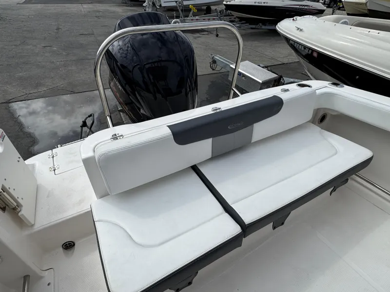 Slide: The Image of 2021 Robalo R222 Explorer boat interior with cushioned seating and motor view. - 4