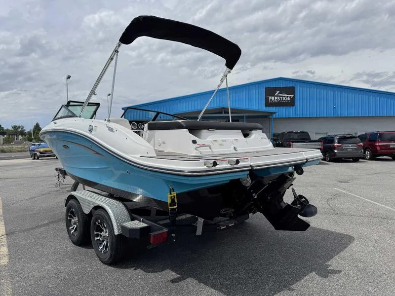Slide: The Image of 2022 Sea Ray SPX 190 boat on trailer, parked outside a blue building. - 4