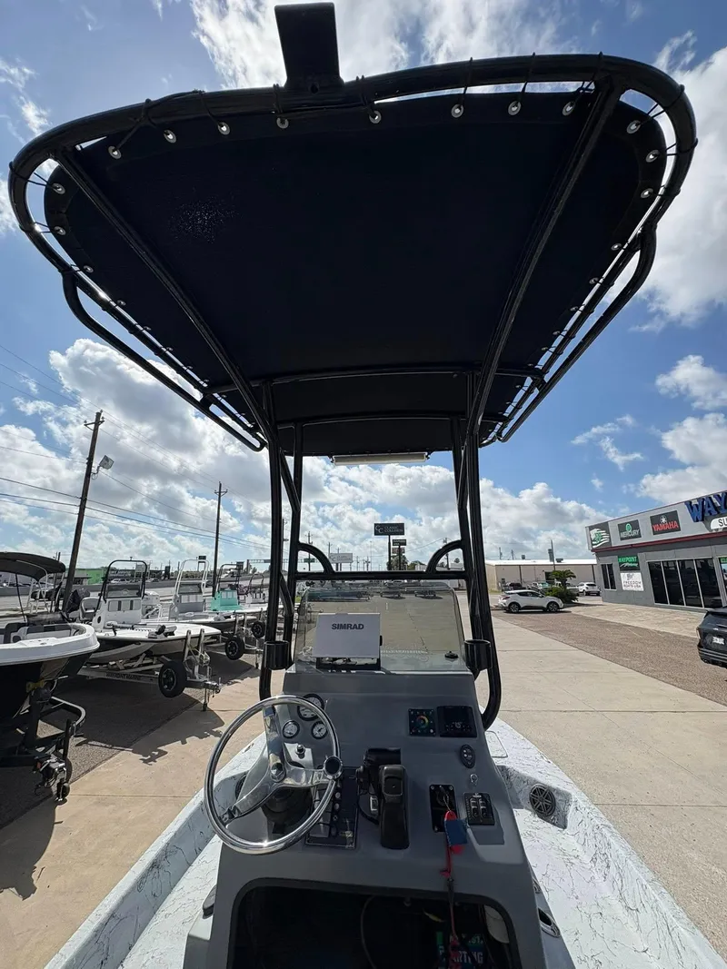 Slide: The Image of 2014 Shoalwater 21 Catamaran boat interior with steering wheel and control panel under canopy. - 12