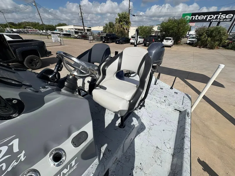 Slide: The Image of 2014 Shoalwater 21 Catamaran boat interior with steering wheel and seat, parked outdoors. - 8