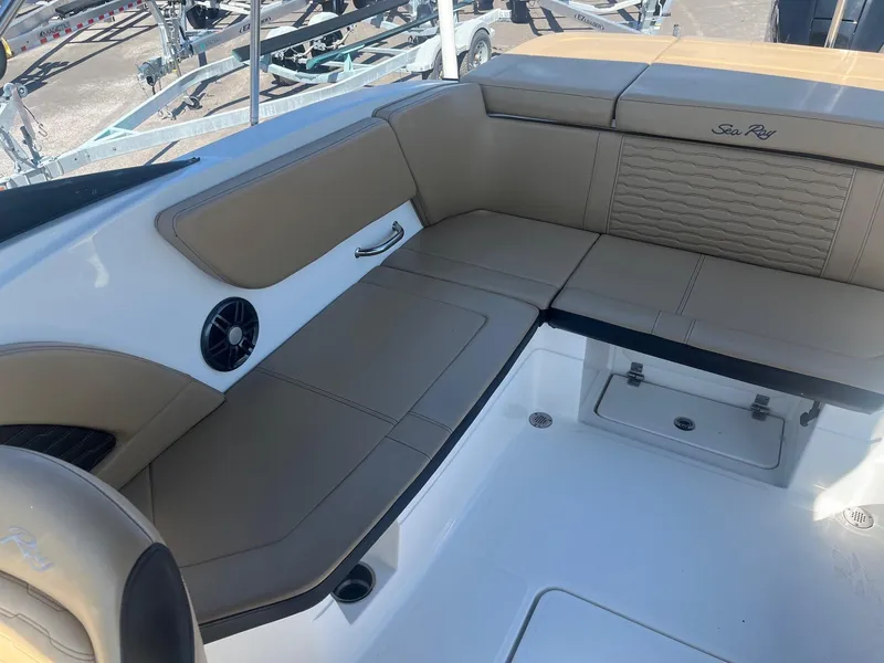 Slide: The Image of 2024 Sea Ray SPX 230 Outboard interior with beige seating and storage compartments. - 10