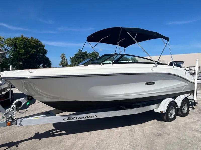 Slide: The Image of 2024 Sea Ray SPX 230 Outboard boat on trailer under clear blue sky. - 2