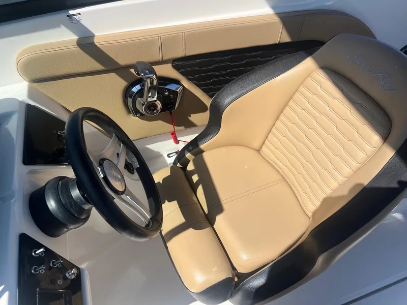 Slide: The Image of 2024 Sea Ray SPX 230 Outboard cockpit with tan seat and steering wheel. - 5