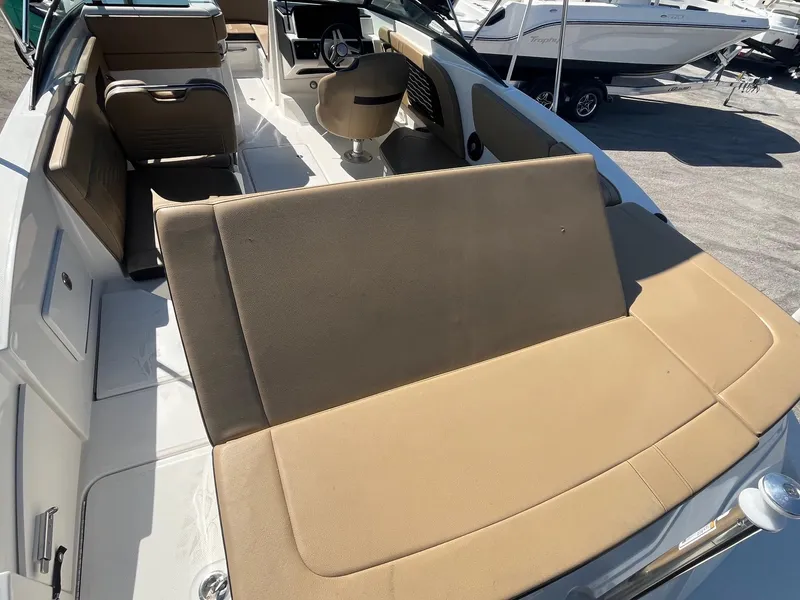 Slide: The Image of 2024 Sea Ray SPX 230 Outboard boat interior with tan seating and steering console. - 7