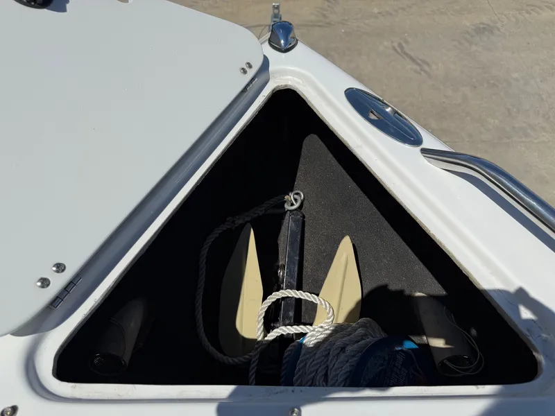 Slide: The Image of Open anchor compartment on 2004 Crownline 266 BR boat, showing anchor and rope storage. - 11