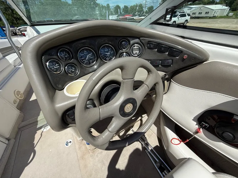 Slide: The Image of 2004 Crownline 266 BR boat dashboard with steering wheel and gauges. - 14