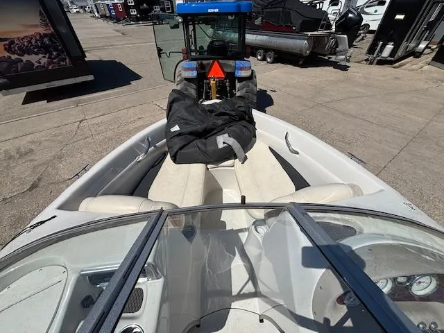Slide: The Image of 2014 Tracker Tahoe Q5 boat interior with tractor in background, parked on concrete surface. - 13
