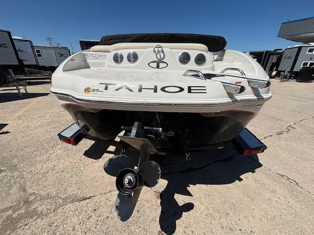 Slide: The Image of 2014 Tracker Tahoe Q5 boat rear view with propeller, parked on concrete under clear sky. - 3