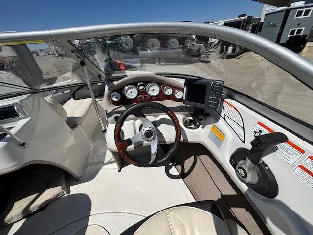 Slide: The Image of 2014 Tracker Tahoe Q5 boat dashboard with steering wheel and gauges under clear blue sky. - 8
