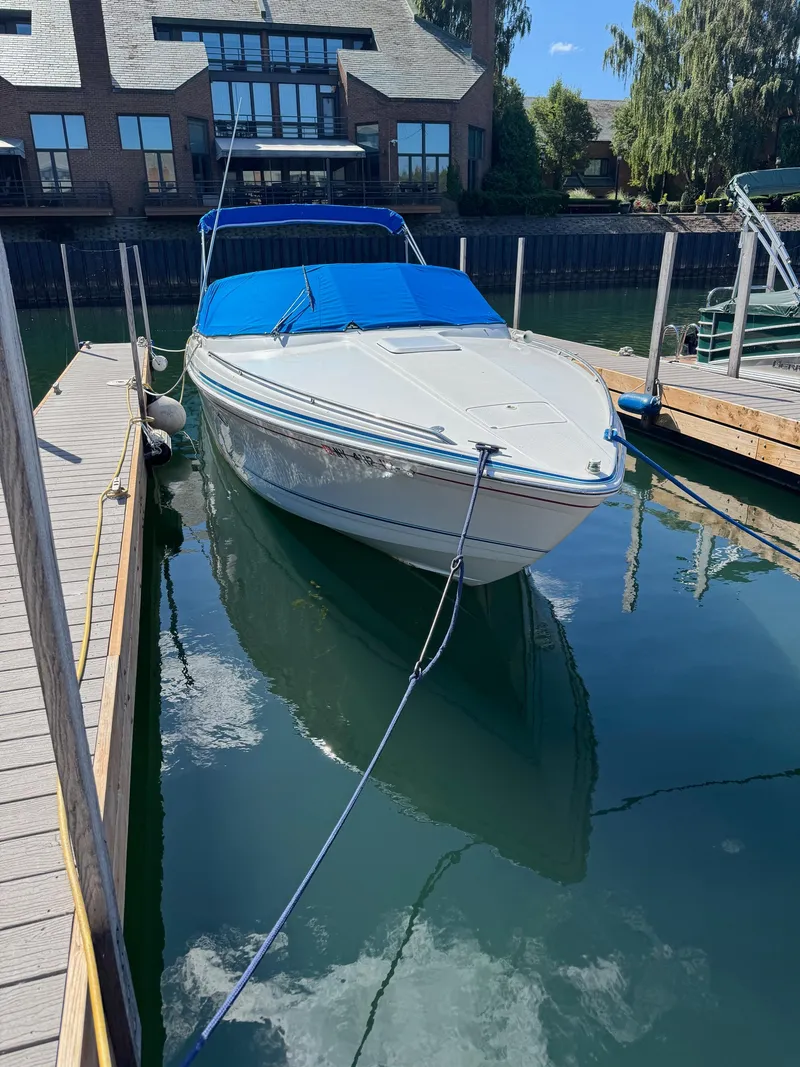 Slide: The Image of 1996 Formula 280 SS boat docked with blue cover, reflecting on calm water. - 1