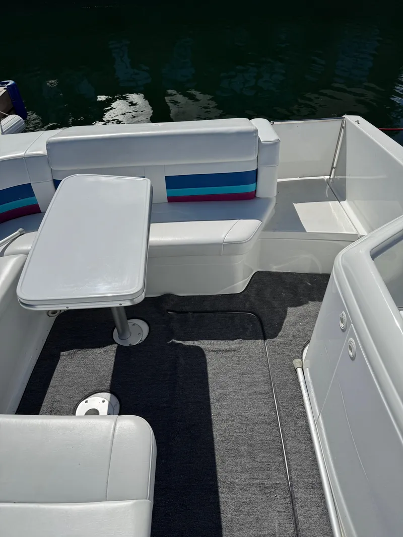 Slide: The Image of 1996 Formula 280 SS boat interior with seating and table, docked on calm water. - 12
