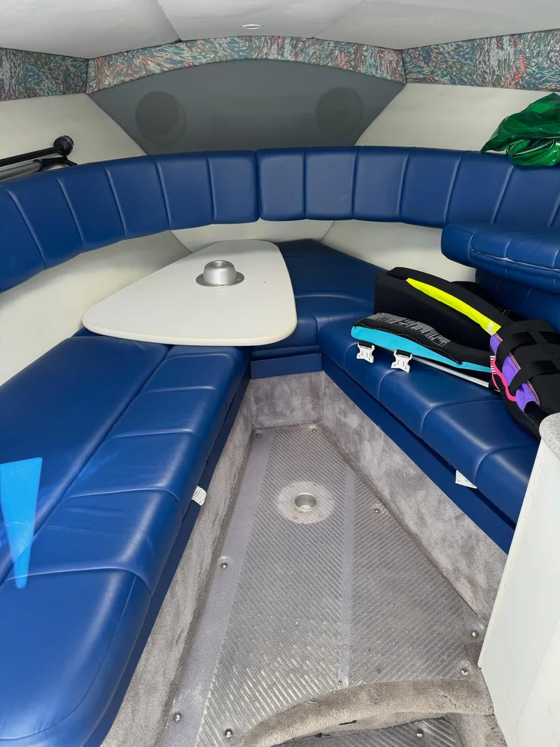Slide: The Image of Interior of a 1996 Formula 280 SS boat with blue seating and a small table. - 15