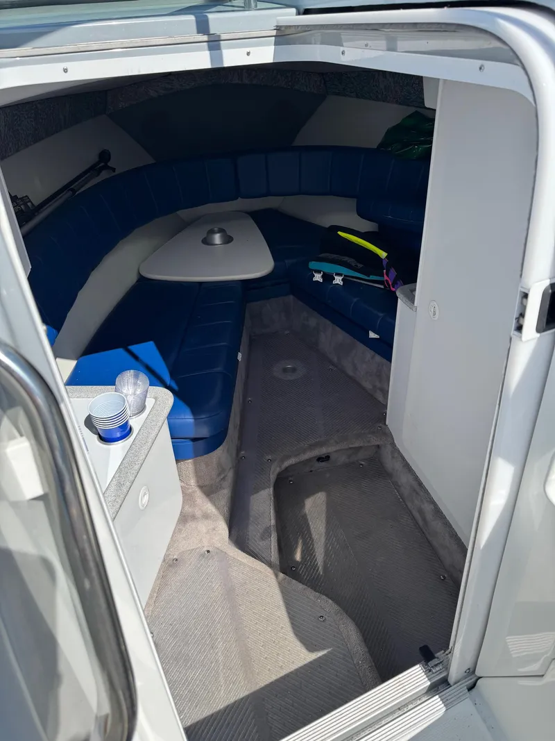 Slide: The Image of Interior of a 1996 Formula 280 SS boat with blue seating and a small table. - 16