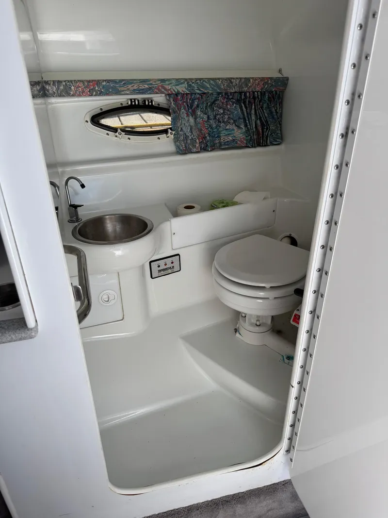 Slide: The Image of 1996 Formula 280 SS boat bathroom with sink, toilet, and window curtain. - 18