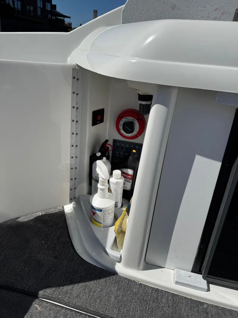 Slide: The Image of Storage compartment in a 1996 Formula 280 SS boat with cleaning supplies and control panel. - 19