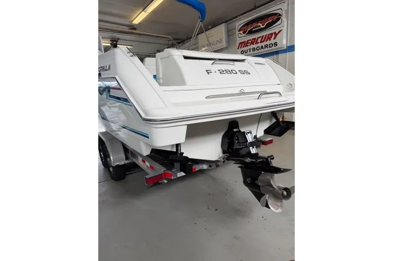 Slide: The Image of 1996 Formula 280 Sun Sport boat in garage, rear view with Mercury outboards signage. - 27