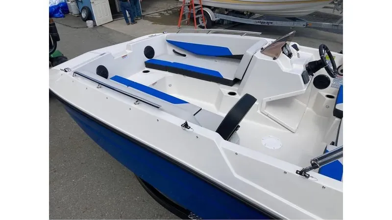 Slide: The Image of 2025 Starcraft SV 16 OB boat with blue and white interior, docked outdoors. - 4