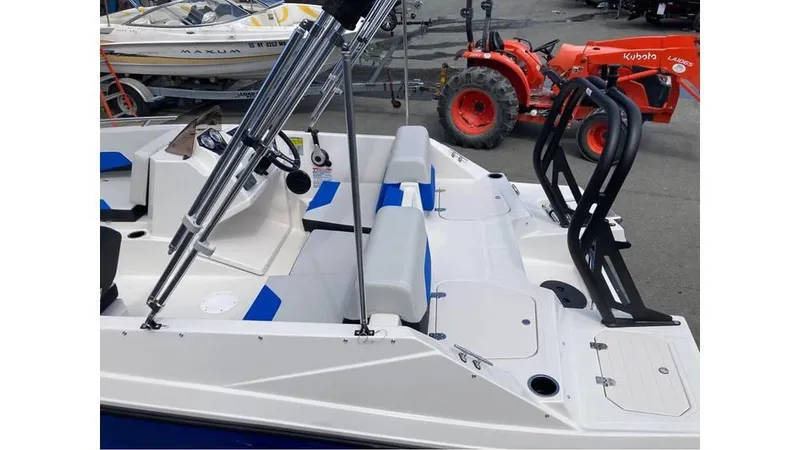 Slide: The Image of 2025 Starcraft SV 16 OB boat interior with seating and equipment, parked near a red tractor. - 5