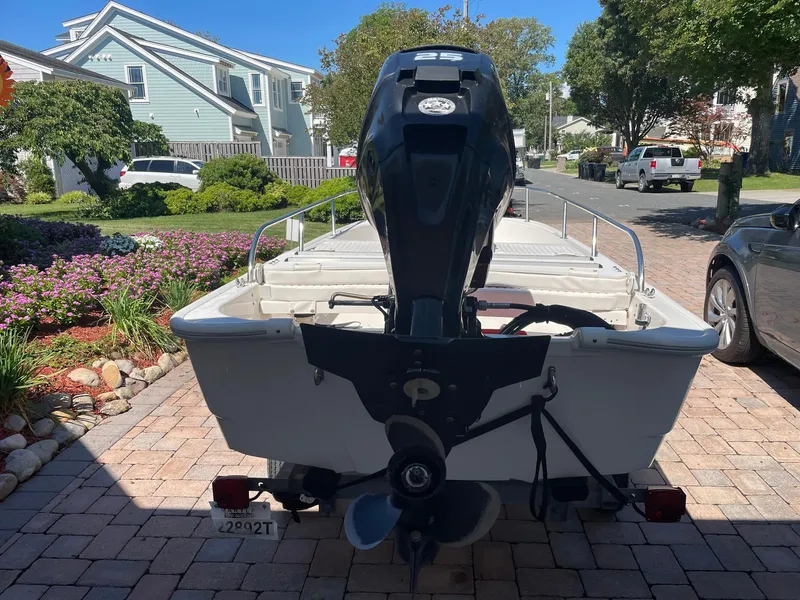 Slide: The Image of 2015 Boston Whaler 110 Sport boat with outboard motor on a driveway. - 23