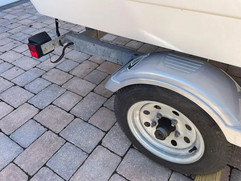 Slide: The Image of Trailer wheel and light of a 2015 Boston Whaler 110 Sport on brick pavement. - 26