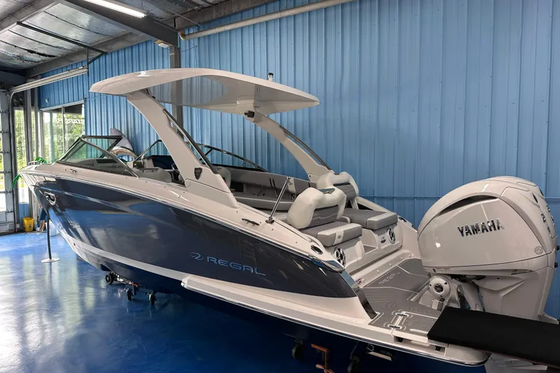 Slide: The Image of 2026 Regal LX9 boat with Yamaha engine in a blue indoor showroom. - 2