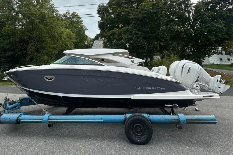 Slide: The Image of 2026 Regal LX9 boat on trailer, sleek design, dual Yamaha engines, parked outdoors. - 28