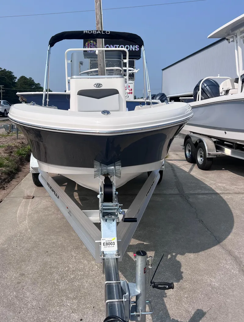Slide: The Image of 2025 Robalo R160 Center Console boat on trailer, parked outdoors. - 2