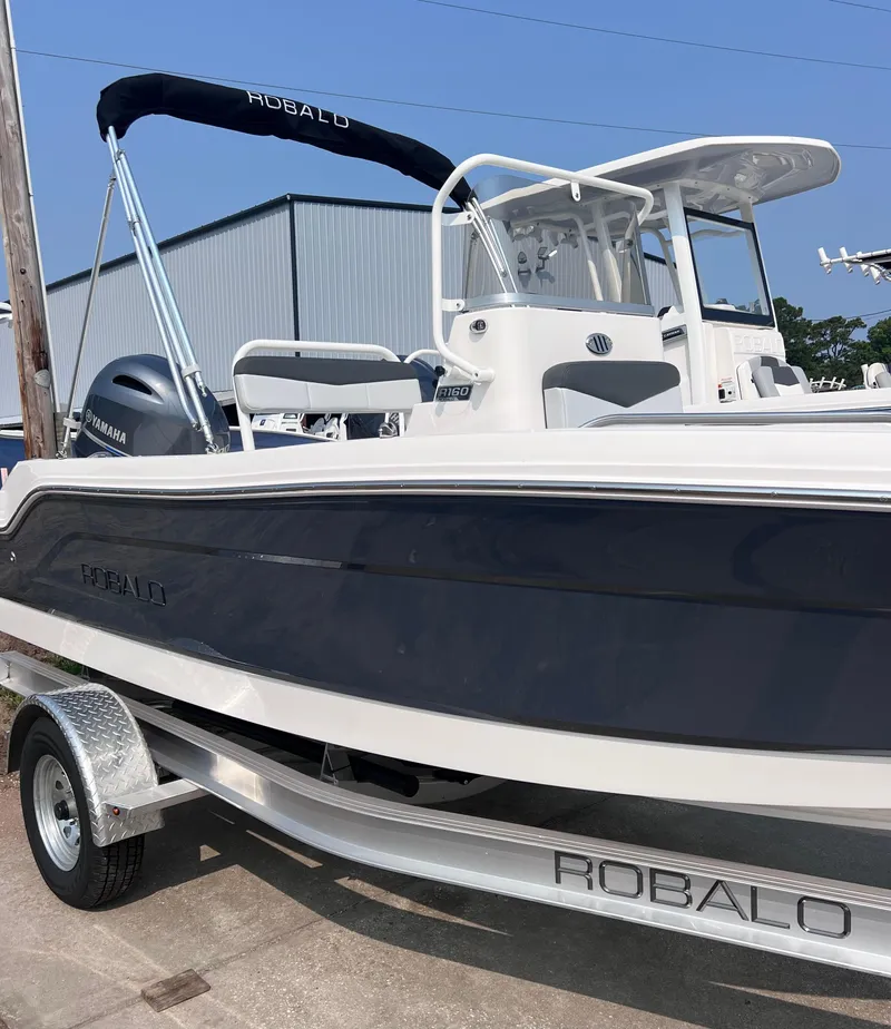 Slide: The Image of 2025 Robalo R160 Center Console boat on trailer, featuring sleek design and Yamaha engine. - 3