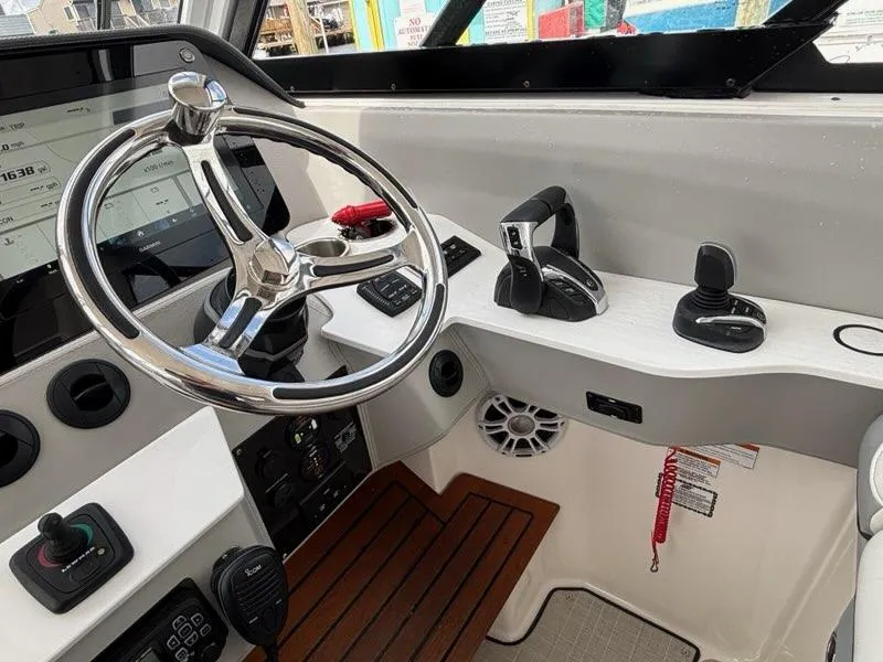 Slide: The Image of 2022 Regal LX36 boat helm with steering wheel, controls, and navigation display. - 13