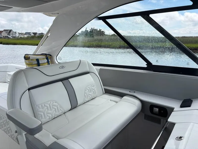 Slide: The Image of 2022 Regal LX36 boat interior with luxurious seating and scenic water view. - 17