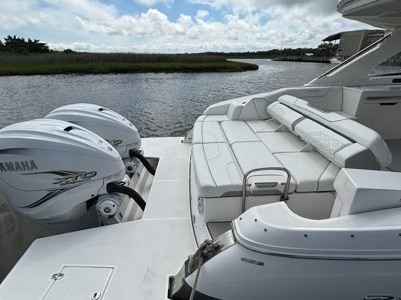 Slide: The Image of 2022 Regal LX36 boat with Yamaha engines, featuring spacious seating by the water. - 20