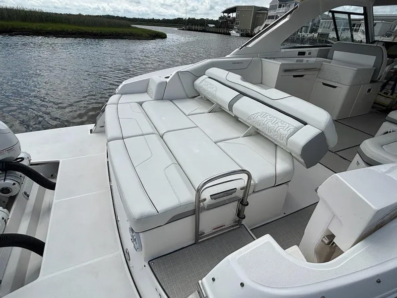 Slide: The Image of Luxurious 2022 Regal LX36 boat interior with white seating, docked by a serene waterway. - 21