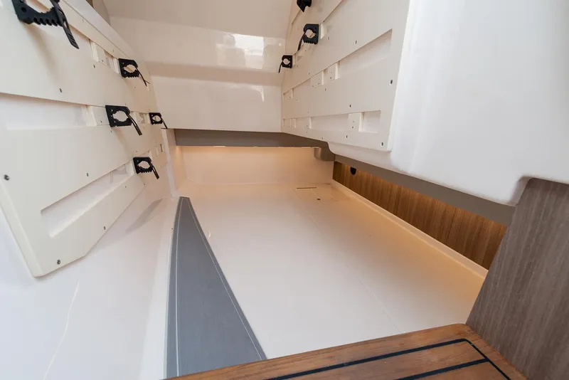 Slide: The Image of Manufacturer Provided Image: Interior storage space of a 2022 Regal LX36 boat with white and wooden finishes. - 37
