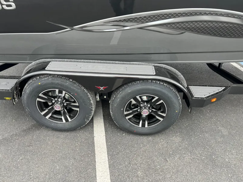 Slide: The Image of 2025 Vexus ADX 200 trailer with dual black alloy wheels on asphalt. - 4