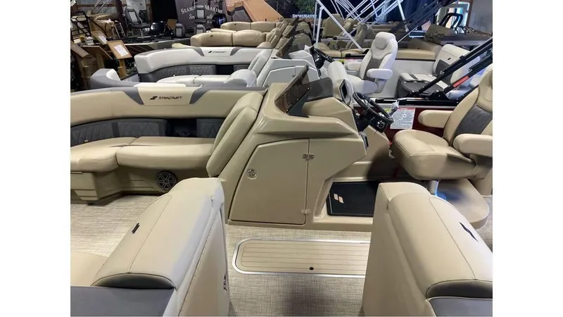 Slide: The Image of 2024 Starcraft CX 23 DL BAR pontoon boat interior with beige seating and modern helm. - 10