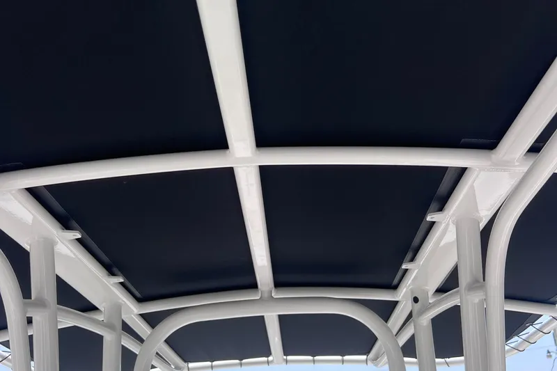 Slide: The Image of 2024 Robalo R200 Center Console T-top frame, featuring sturdy white metal construction. - 11