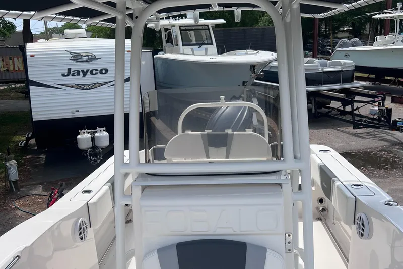 Slide: The Image of 2024 Robalo R200 Center Console boat in a marina, with a Jayco trailer nearby. - 18
