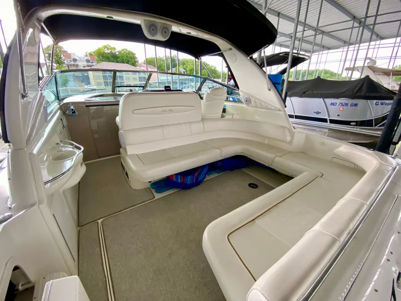 Slide: The Image of 1999 Sea Ray 400 Sundancer interior with spacious seating under a covered dock. - 10