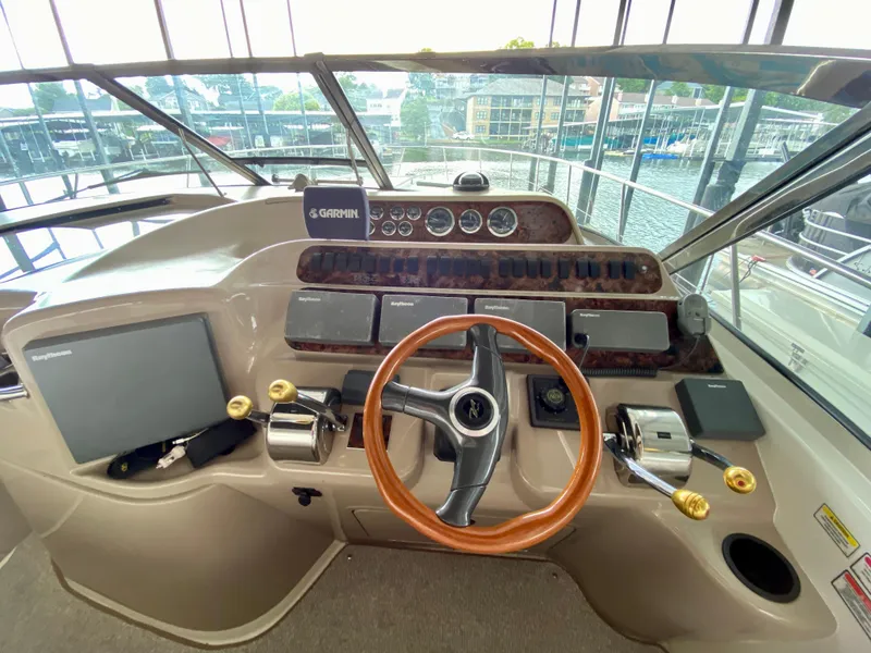 Slide: The Image of 1999 Sea Ray 400 Sundancer helm with Garmin navigation, wood steering wheel, and control panels. - 15