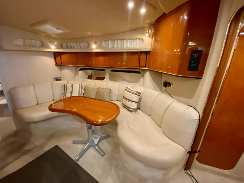 Slide: The Image of Luxurious interior of 1999 Sea Ray 400 Sundancer yacht with plush seating and wooden table. - 19